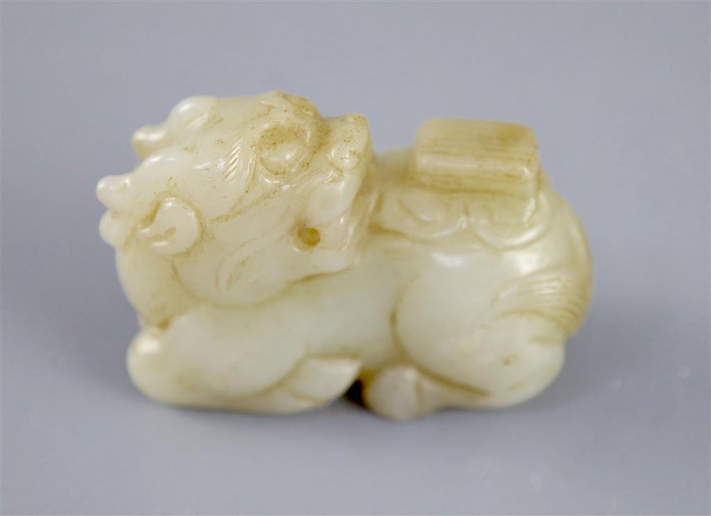 A Chinese pale celadon jade figure of a recumbent qilin, 5.4cm